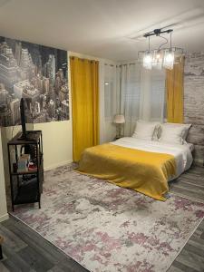 a bedroom with a large bed with yellow curtains at Lodgespa : Maison Rose in Hésingue