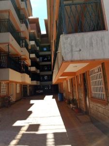 un callejón entre dos edificios con el sol brillando sobre ellos en Denverwing Homes. en Eldoret