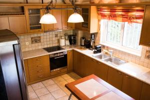 a kitchen with wooden cabinets and a sink and a window at POOL Family House 500m from beach Southplace63 in Vari