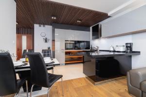 a kitchen and dining room with a table and chairs at Diamond Apartment by Renters Prestige in Kraków