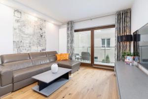 a living room with a couch and a table at Diamond Apartment by Renters Prestige in Kraków