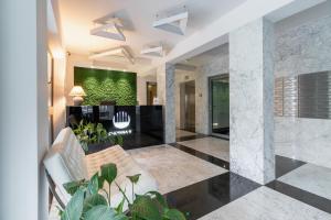 a lobby with a white couch and a green wall at Diamond Apartment by Renters Prestige in Krakow