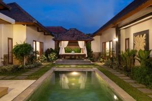 a villa with a swimming pool in front of a house at Villa Lapiz Lazuli Seminyak Kuta in Seminyak