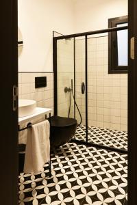 a bathroom with a black tub and a sink at Architect's Art House right on Taksim Square in Istanbul