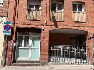 ein Backsteingebäude mit einer Tür und einem Balkon in der Unterkunft Bonito Apto Cinco Torres Plaza Castilla in Madrid