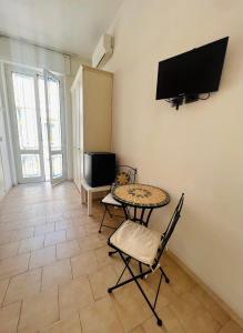 uma sala de estar com uma mesa e cadeiras e uma televisão em A casa di Mario e Nenè em Viareggio