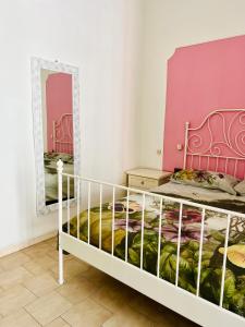 um quarto com uma cama branca e um espelho em A casa di Mario e Nenè em Viareggio