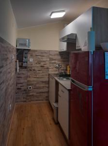 een keuken met een rode koelkast en houten vloeren bij Young Family App in Medulin
