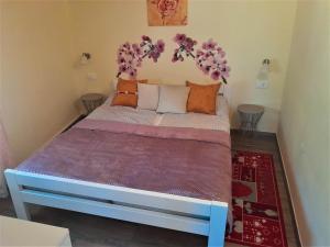 een slaapkamer met een bed met paarse en oranje kussens bij Young Family App in Medulin