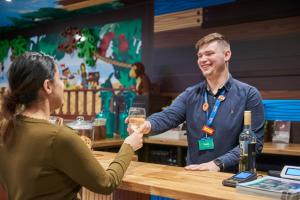 a man handing a woman a glass of wine at LEGOLAND(R) Windsor Resort in Windsor
