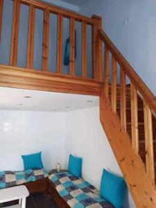 a room with a wooden staircase with blue cushioned chairs at La crique in Alger