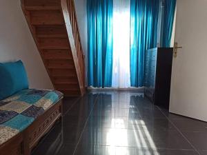 阿爾及爾的住宿－La crique，一间卧室配有床和蓝色窗帘的窗户