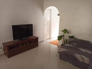a living room with a flat screen tv and a couch at La crique in Alger