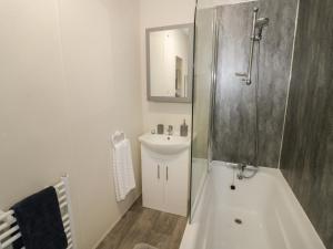 a bathroom with a shower and a sink and a tub at Carolina Lodge in Evesham