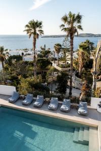 una piscina con palme e vista sull'oceano di PAREA Paros - Adults Only a Kampos Paros