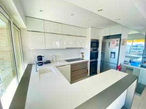 a kitchen with white cabinets and a counter top at Antinéa By SCLS Locations in Cannes