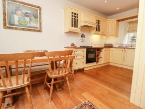 a kitchen with white cabinets and a table and chairs at Harness Lodge in Seahouses +11 photos