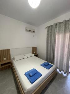 Villa Soni Oruci في كساميل: غرفة نوم عليها سرير وفوط زرقاء