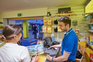 a man paying a woman in a store at LEGOLAND(R) Windsor Resort in Windsor