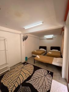 um quarto com duas camas e um tapete no chão em MyDusun Chalet, Taiping, Perak, Malaysia em Taiping