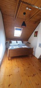 艾傑克的住宿－Buborék Apartman - Etyek，一张位于带木制天花板的客房内的大床