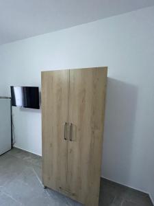 Villa Soni Oruci في كساميل: خزانة خشبية في غرفة مع ثلاجة