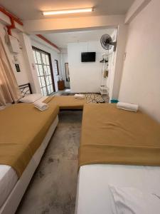 a room with two beds and a flat screen tv at MyDusun Chalet, Taiping, Perak, Malaysia in Taiping