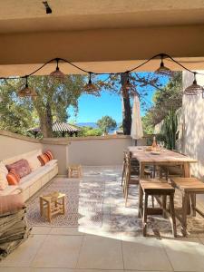 un patio con sofá, mesa y sillas en Casetta Cala Rossa, en Lecci