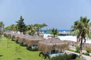 a row of straw umbrellas on a beach at MIRADA DEL MAR HOTEL in Antalya