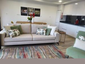 a living room with a couch and a kitchen at NORTHEAST PORTUGAL G in Mirandela