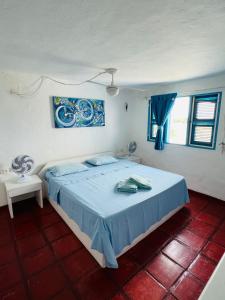 um quarto com uma cama com um edredão azul em MYKONOS HOUSE em Aquiraz