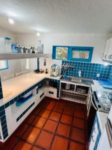 uma cozinha com azulejos azuis e brancos e um lavatório em MYKONOS HOUSE em Aquiraz