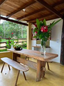 a wooden table with a vase of flowers on it at Eco Lodge in Alto Paraíso de Goiás