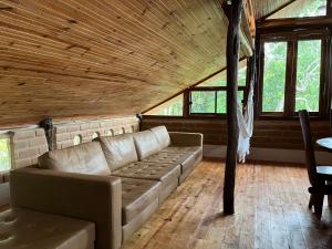 a living room with a couch and some windows at Eco Lodge in Alto Paraíso de Goiás