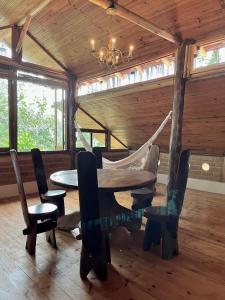 ein Esszimmer mit einem Tisch, Stühlen und einer Hängematte in der Unterkunft Eco Lodge in Alto Paraíso de Goiás