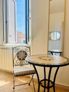 a table and a chair in a room with a window at A casa di Mario e Nenè in Viareggio