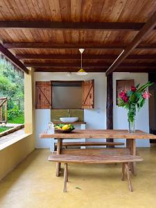 einen Tisch mit einer Schale Obst und einer Vase Blumen in der Unterkunft Eco Lodge in Alto Paraíso de Goiás