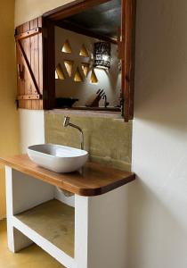 La salle de bains est pourvue d'un lavabo et d'un miroir. dans l'établissement Eco Lodge, à Alto Paraíso de Goiás