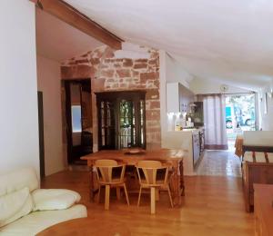 a kitchen and dining room with a table and chairs at Les Chambres du Clos des Capucins in Barjac