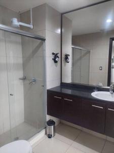 y baño con ducha acristalada y lavamanos. en ZAFIRO SUITE CON VISTA CIUDAD/PISCINA/GYM/ PARQUEO, en Guayaquil