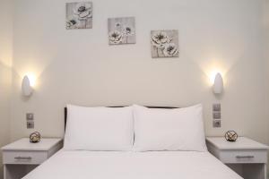 a bedroom with a white bed with two night stands at Dellis House in Vouniatádes