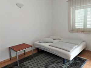 a small bedroom with a bed and a table at Apartments Aurora near beach in Medulin