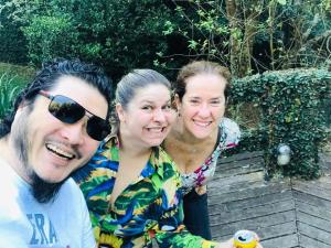 a group of three people posing for a picture at Chalé Serra Cantareira in Mairiporã