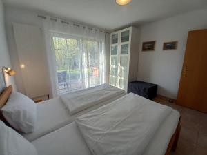 a bedroom with a large white bed with a window at Ferienwohung Charlotte in Usedom Town
