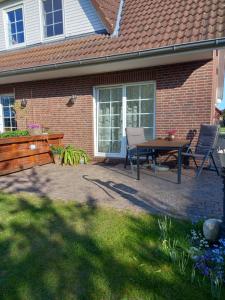 a patio with a table and chairs in front of a house at Ferienwohung Charlotte in Usedom Town