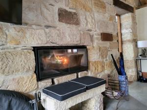 a stone wall with a fireplace in a room at The Cottage Burradoo in Burradoo