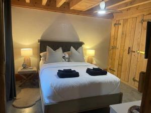um quarto com uma cama branca com duas toalhas em The Cottage Burradoo em Burradoo