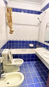a blue tiled bathroom with a toilet and a sink at درة العروس - القرية الحالمة - شقة دور أرضي على البحر - Dream Village in Durat Alarous