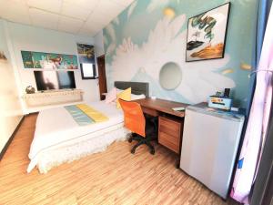 a bedroom with a bed and a desk with a computer at 金廈之星 in Jinning