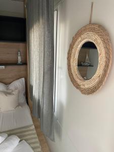 um espelho pendurado numa parede ao lado de uma cama em Mobile Homes Fran em Privlaka